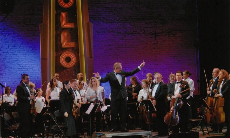 David Eaton with the NYC Symphony and students from the Harlem School of the Arts share a bow at the Apollo Theater.
